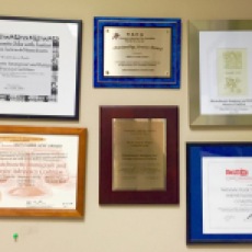 Certificates and awards for the MIRA Coalition hang together on a wall.
